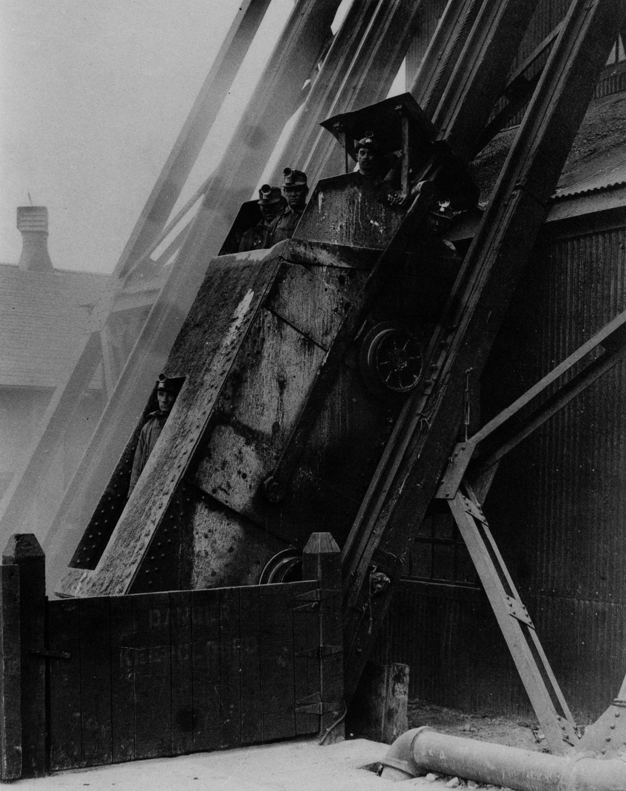 Men being lowered by skip into Lyon Mountain Mine in Lyon Mountain
