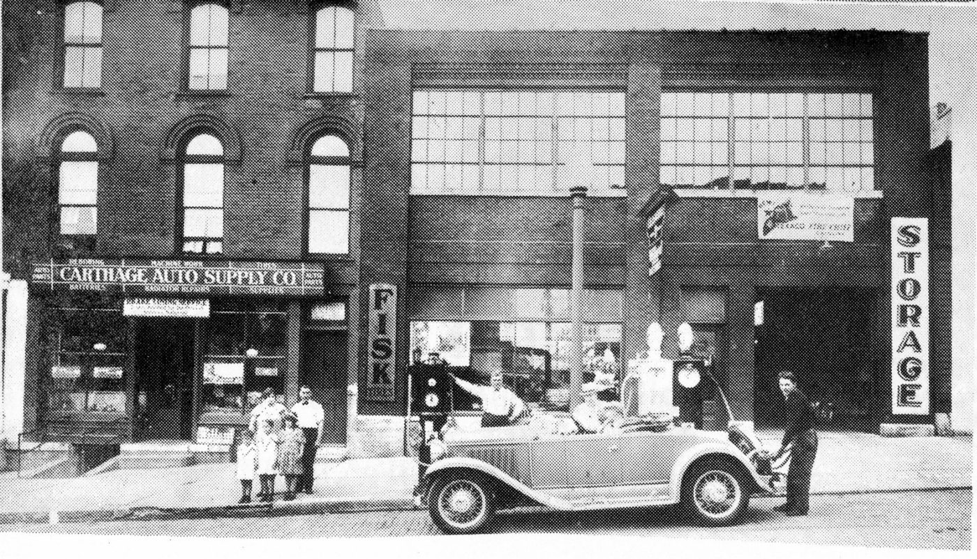 Carthage Auto Supply Company owners in front of the newest cars in
