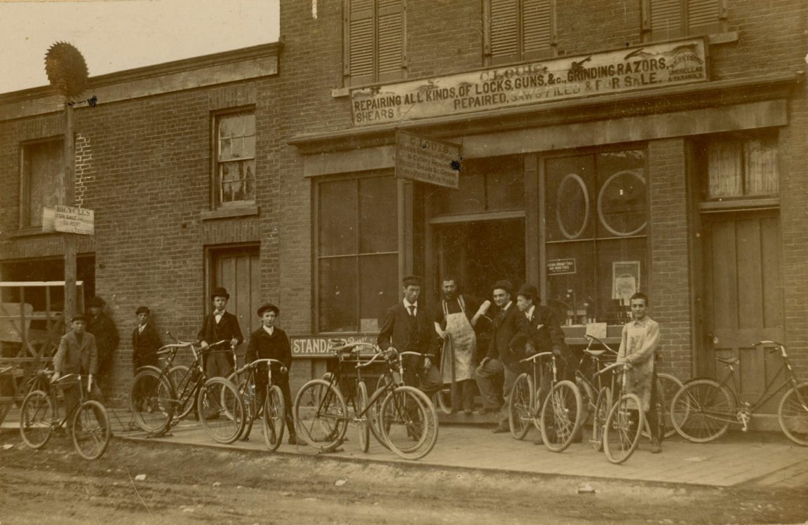 Boys with bikes outside the C. Louis repair store in Ogdensburg