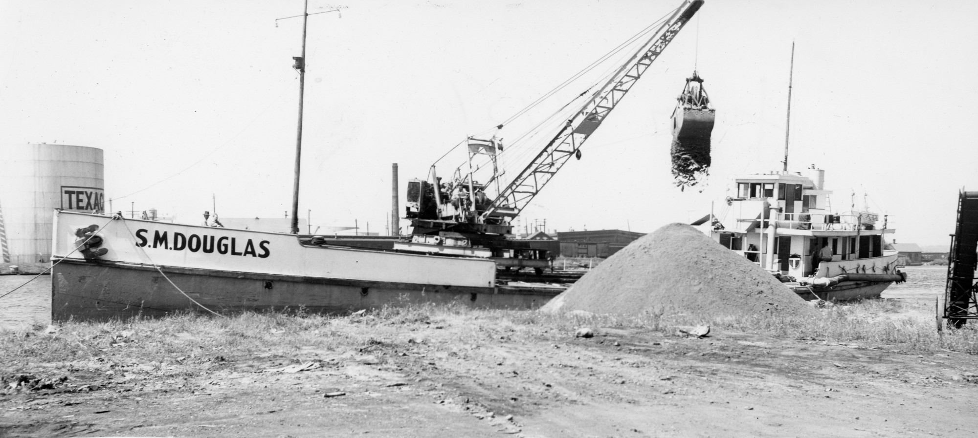 Crane unloads gravel from a barge in Ogdensburg