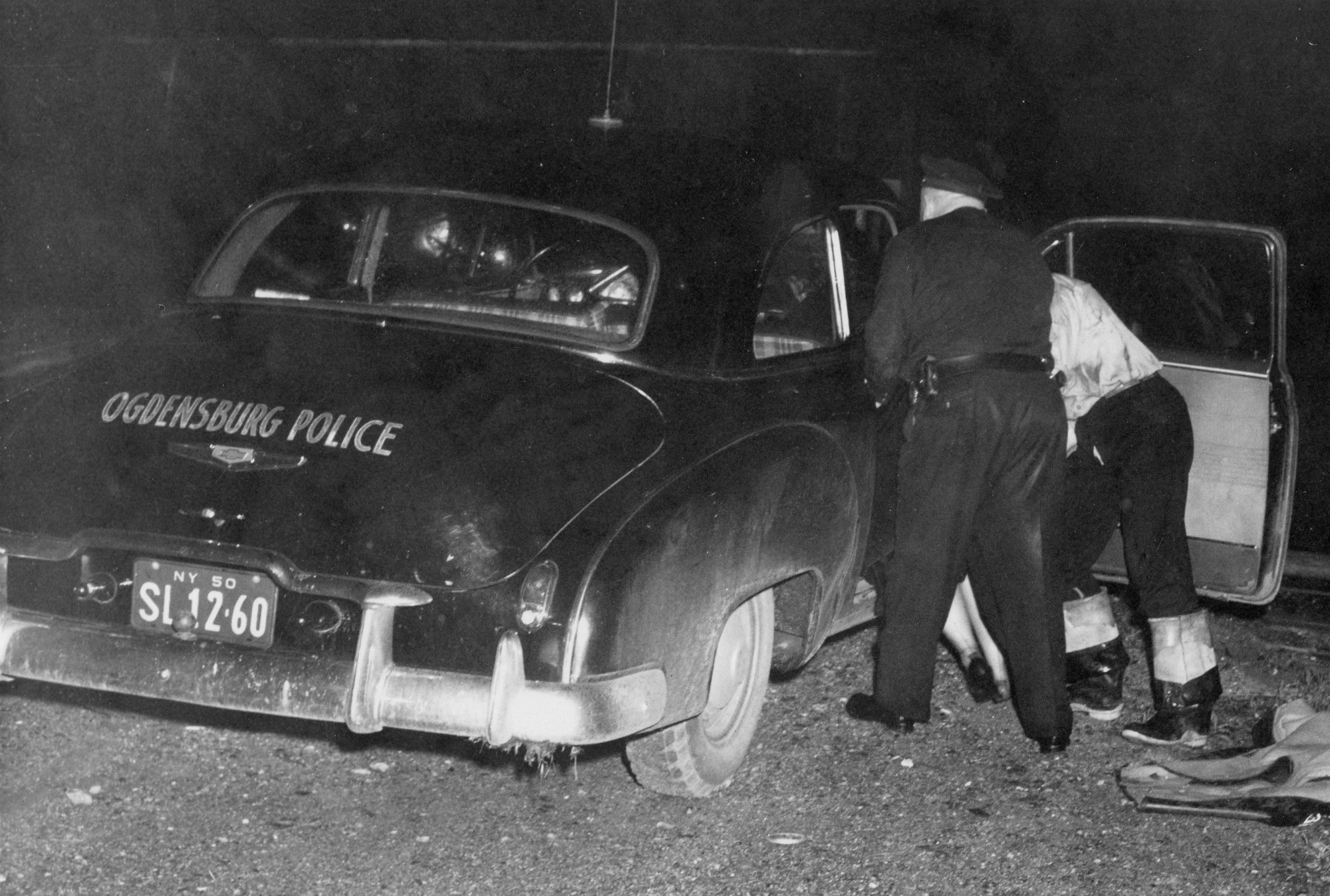 Police put a person into the back of a cruiser in Ogdensburg