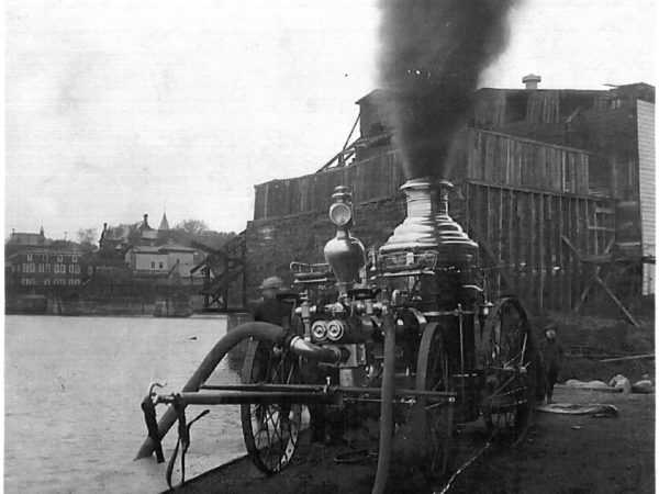 Firemen fill a steam pumper from the Black River in Carthage