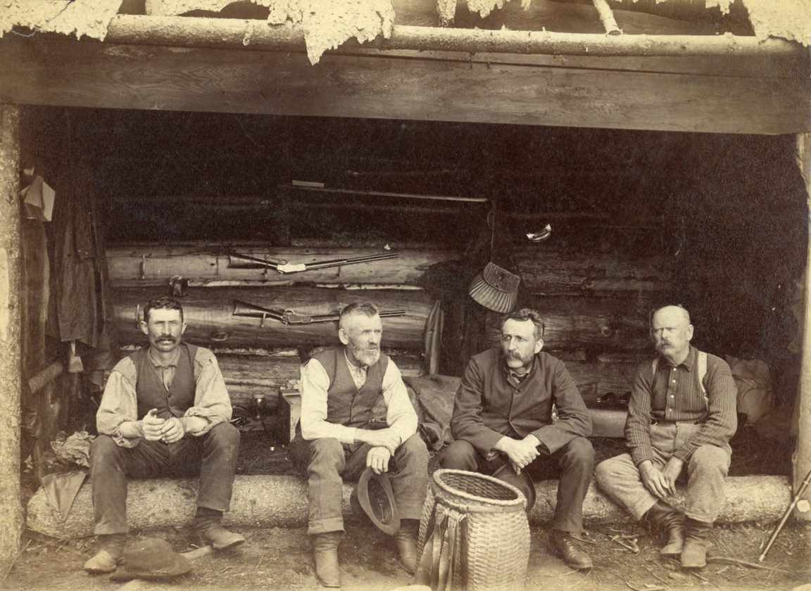 Four hunting guides in an Adirondack leanto in Cranberry Lake