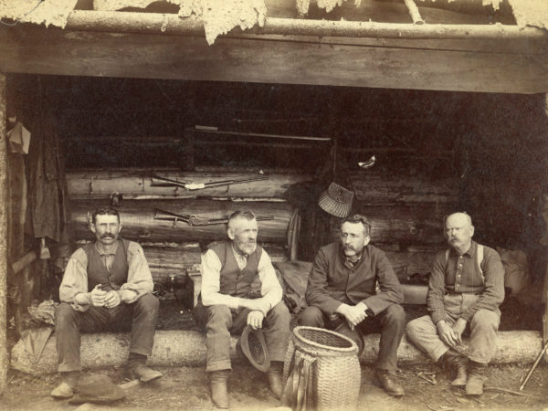 Four hunting guides in an Adirondack lean-to in Cranberry Lake