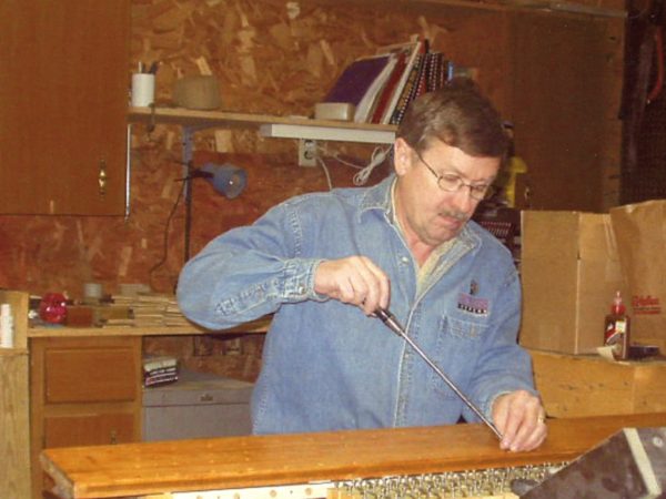 Wayne Lincoln repairing player piano in Massena