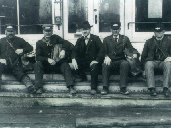 Five postmen sit on the steps of Post Office in Lisbon