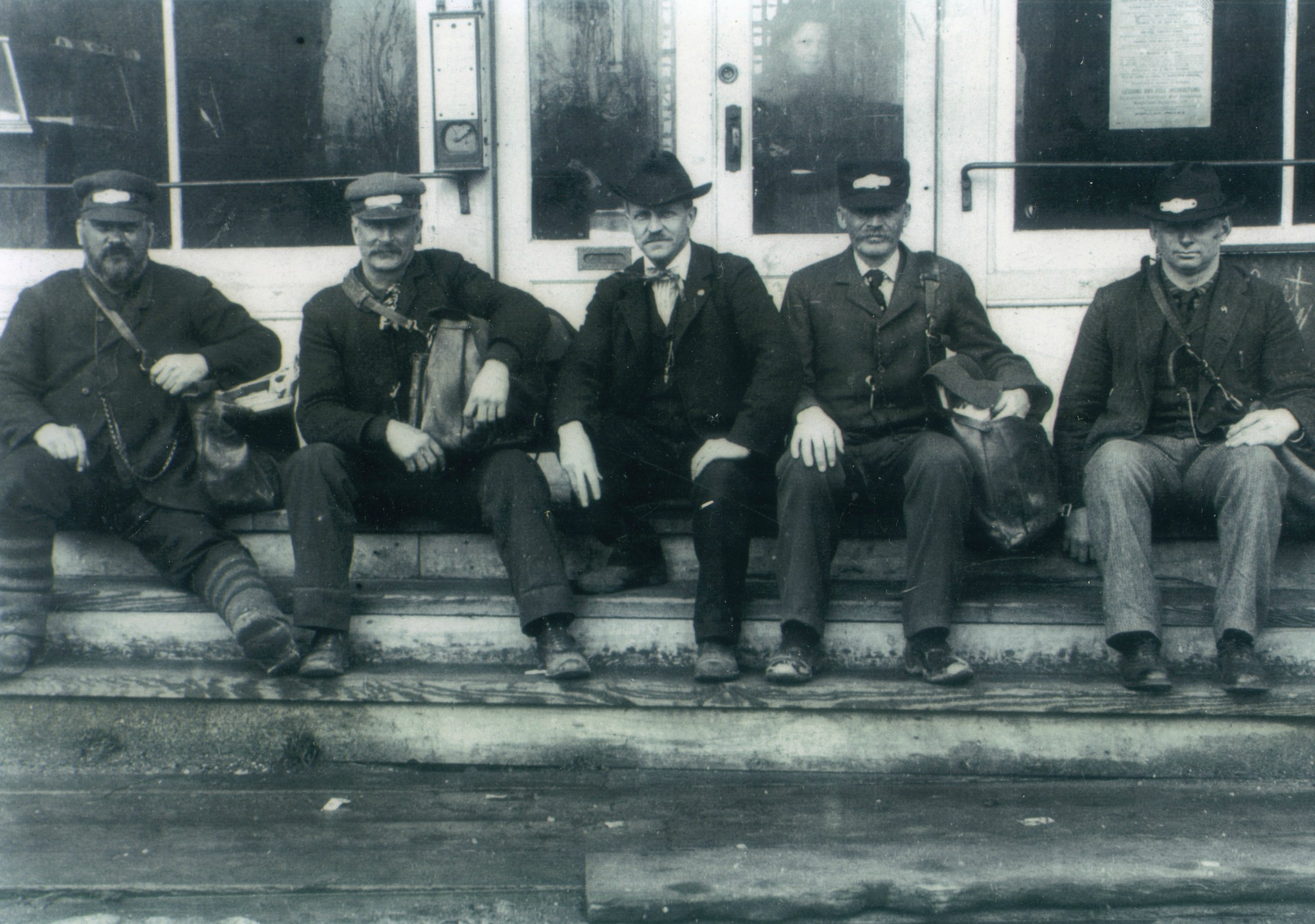 Five postmen sit on the steps of Post Office in Lisbon