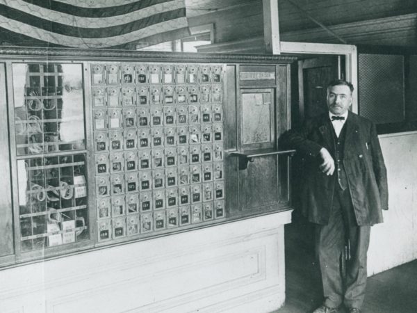 Postmaster inside the post office in De Kalb Junction