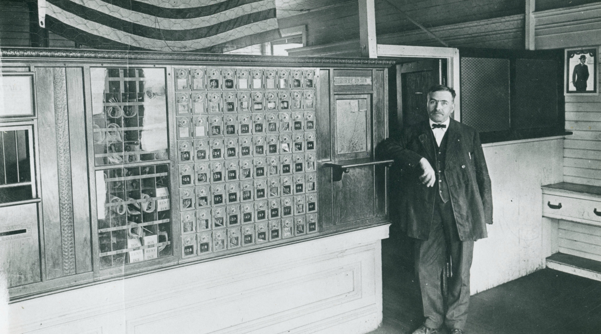 Postmaster inside the post office in De Kalb Junction