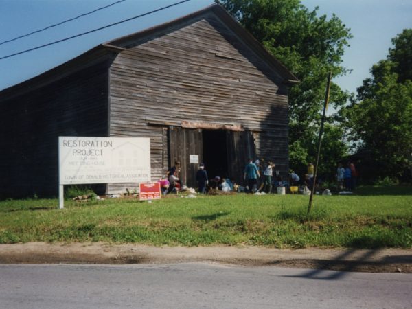 Community members work to clear and restore the old meeting house in East De Kalb