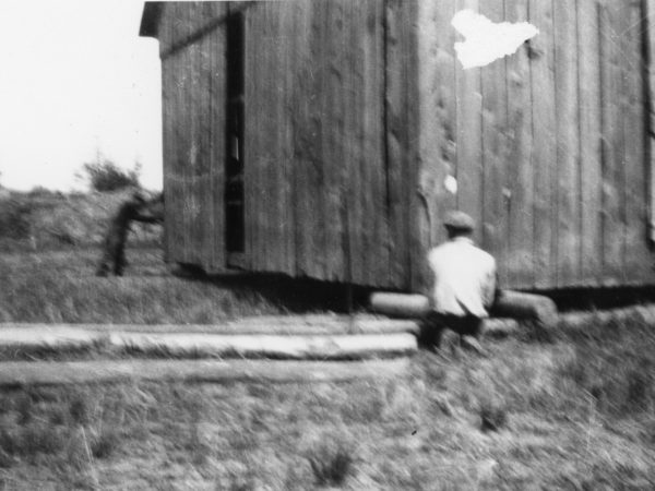 Moving a barn on wooden rollers in the Town of De Kalb