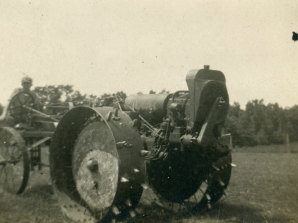 Driving an early Moline tractor in the Town of De Kalb