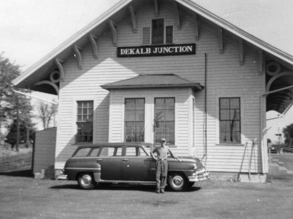 Station Agent in front of the train depot in De Kalb Junction