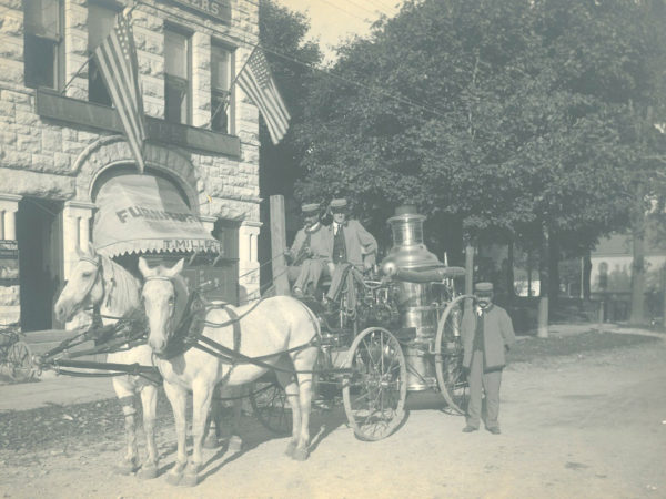 Three volunteer firefighters with the Silas Wright pumper in Canton