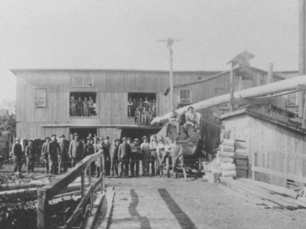 Workers pose in front of a box factory in Rensselaer Falls