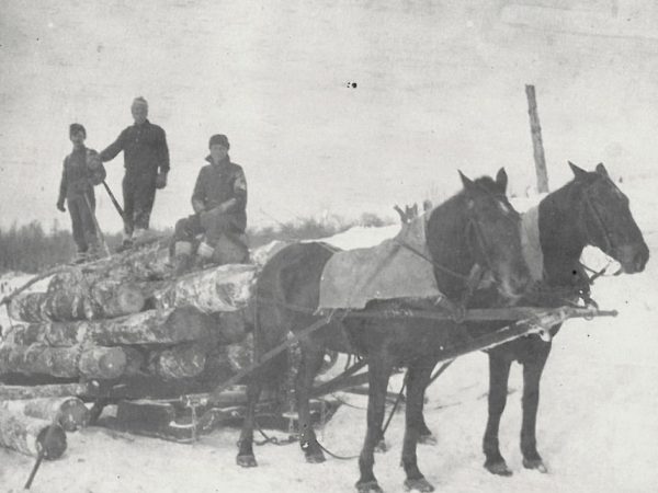 Men with logs on a horse-drawn bobsled in Canton
