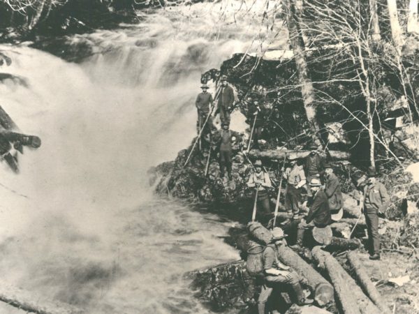 Log drivers posing next to the Grasse River in Canton