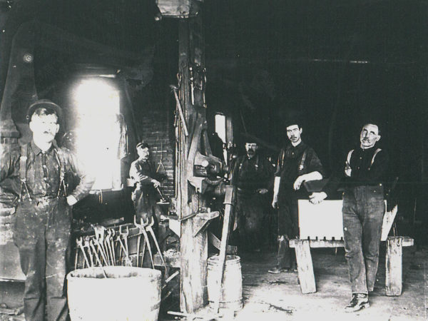 Workers inside Henry Jones General Blacksmith and Machine Shop in Richville