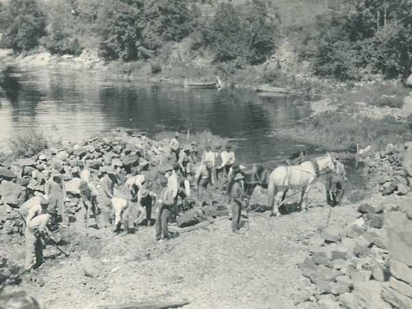 Men and horses moving broken up pieces of “Bullhead Rock” in the Oswegatchie River near De Kalb