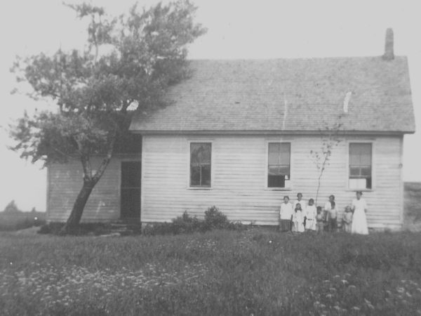 Teacher with her students in front of the Warren School in De Peyster