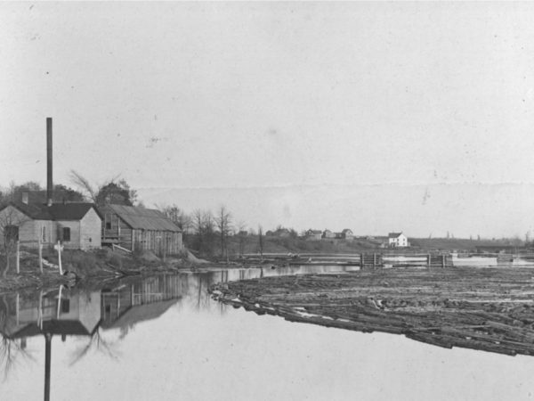 Logs floating in front of a steam sawmill on the Oswegatchie