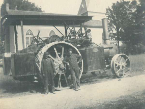 Traction steam engine in front of a church in Saint Lawrence County