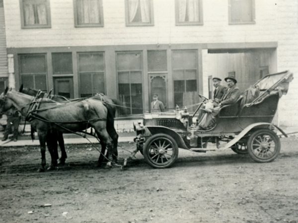 Horse team towing an early automobile on Church Street in downtown Hermon