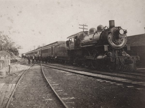 Eleven man crew in front of a passenger train in De Kalb