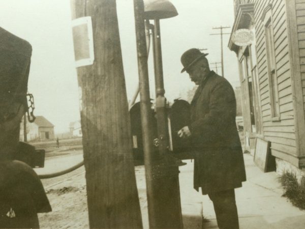 Pumping gas at the Cole drugstore in De Kalb Junction