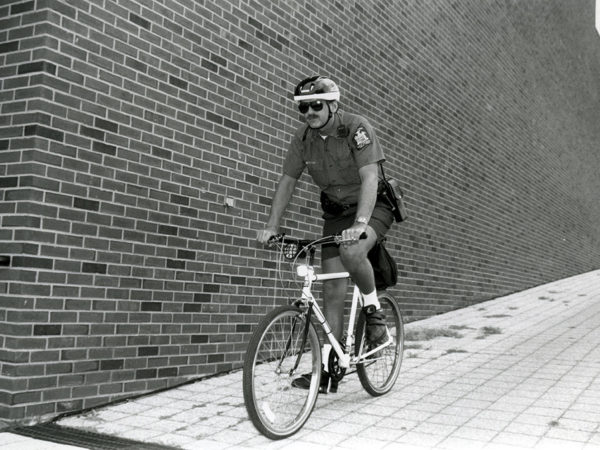 Campus security officer riding a bicycle at SUNY Potsdam in