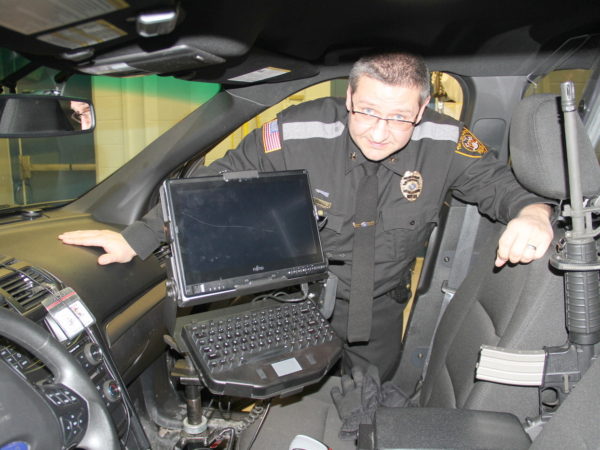 Eric Proulx shows off the inside of a TLPD cruiser in Tupper Lake