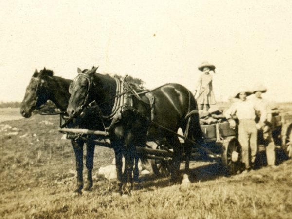 Two men and a girl haul stones in Hammond