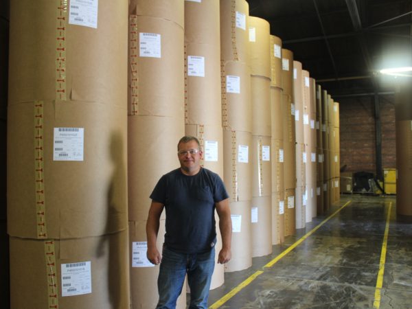 Worker in front of packaged paper rolls in Potsdam