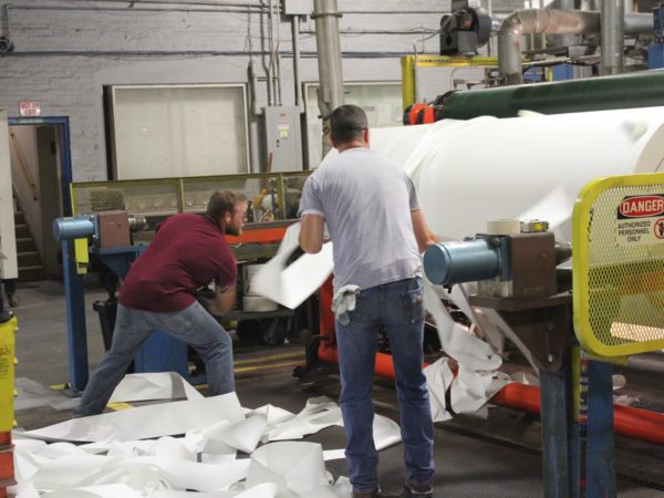 Men make rolls of paper in the Potsdam Specialty Paper Company in Potsdam