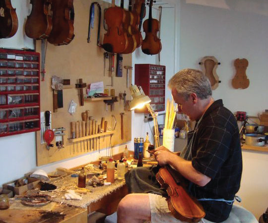 Dustin Saam crafting a violin at The Shirt Factory in Glens Falls