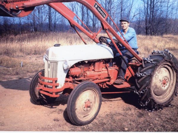 Ross Young on a bulldozer used for logging in Harrisville