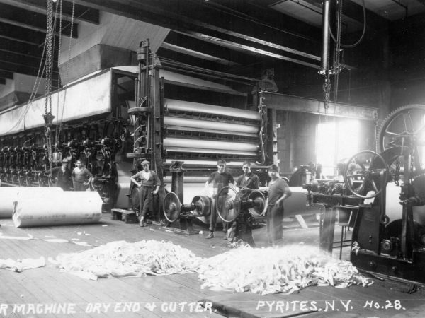 Men with paper machines inside the DeGrasse River Paper Company in Pyrites