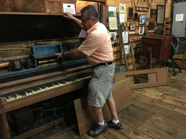 Wayne Lincoln restoring a player piano in Lisbon