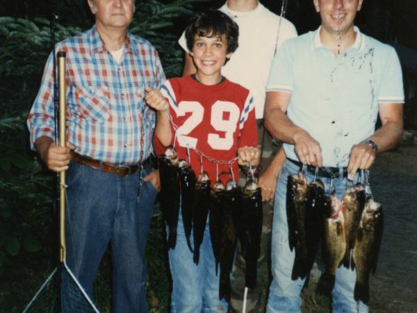 Man with campers after fishing at Northern Frontier Camp in North River