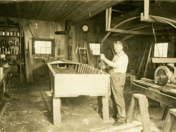 Charles Hanmer working on a boat in Long Lake