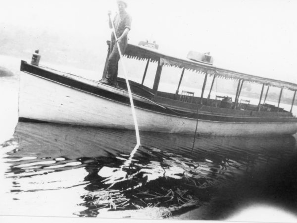 Man rows a pleasure boat in Long Lake