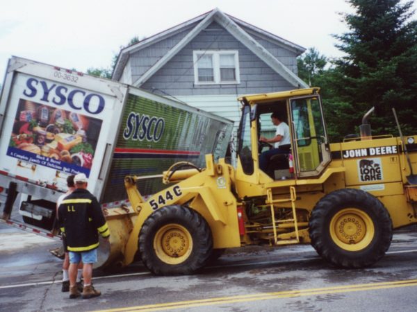 Moving a crashed truck with a tractor in Long Lake