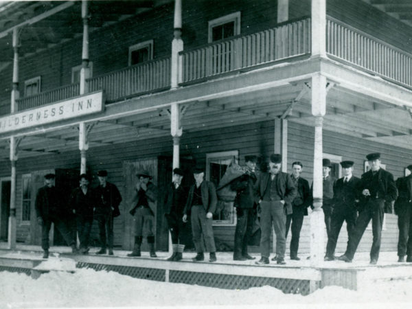 Men on the porch of the Wilderness Hotel in Sabattis