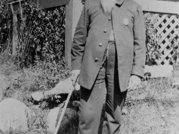 Charles Bailey Hanmer in front of a porch in Long Lake