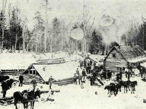 Men and horses at a winter logging camp in the Adirondacks