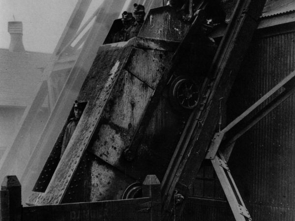 Men being lowered by skip into Lyon Mountain Mine in Lyon Mountain