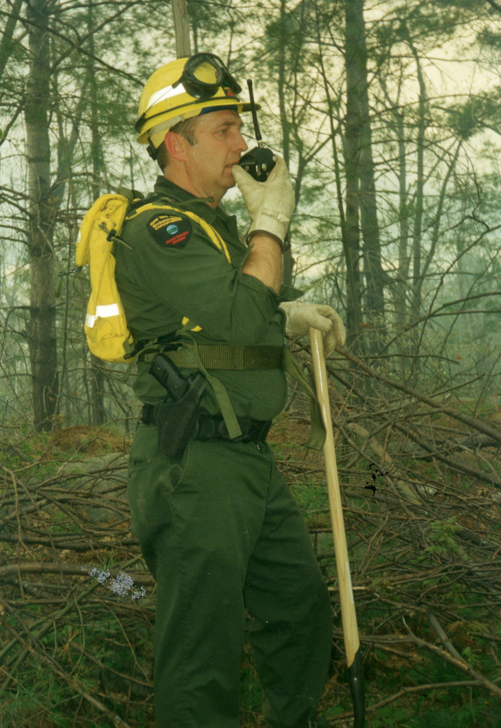 Forest ranger speaks into a walkie-talkie in Rossie