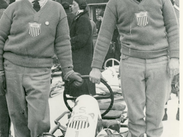 Olympic athletes posing with their bobsled