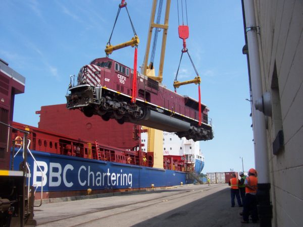 Longshoremen loading a locomotive onto a ship in the Port of Ogdensburg