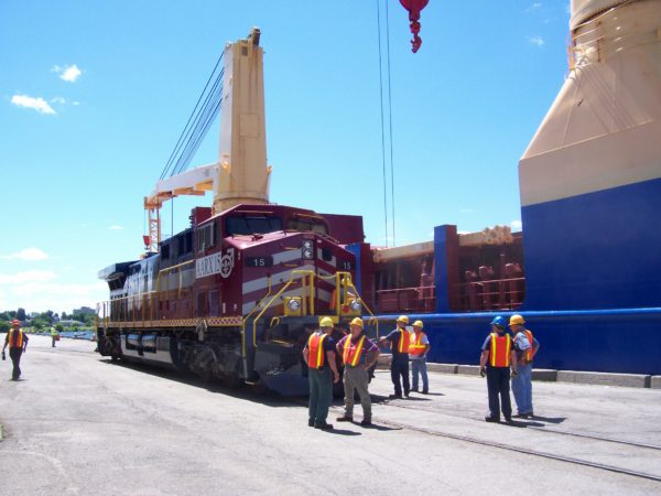 Stevadores loading locomotive onto ship at the Port of Ogdensburg